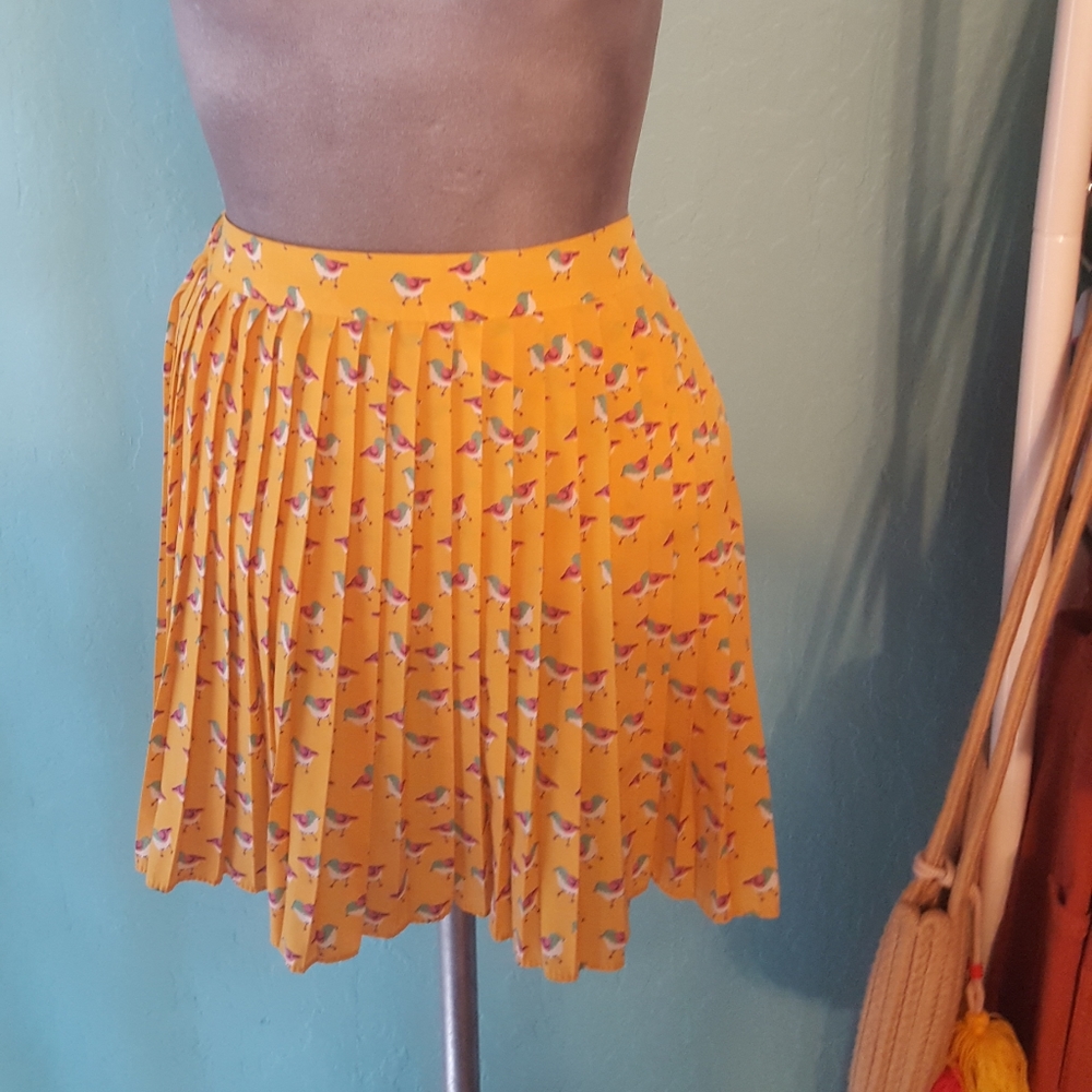 Pleated yellow mini skirt with birds
